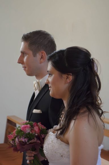 Vor dem Altar der Liebe Hochzeitszeremonie mit Braut und Bräutigam in formeller Kleidung, sie stehen vor dem Pfarrer.